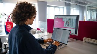 A trainee uses a laptop for research and to write a text