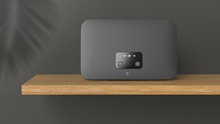 Das Bild zeigt ein Regal auf dem ein Telekom-Router steht. 