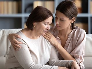 Younger woman consoling older woman.