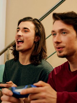 Zwei junge Männer schauen spielen ein Spiel über die Console