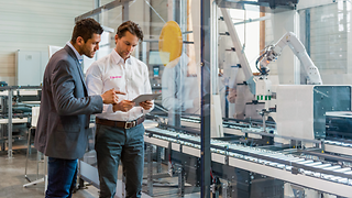 Two men with a tablet on the production line.