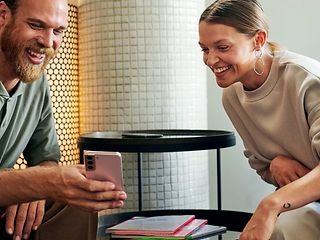 Zwei junge Studierende schauen auf ein Smartphone